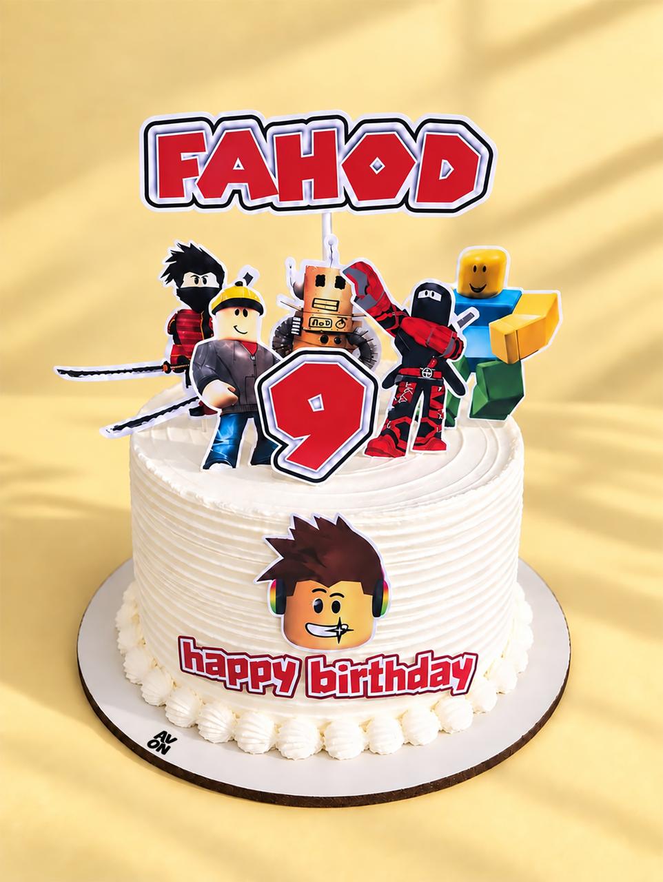 White Roblox cake with character figures, the name FAHOD and the number 9
