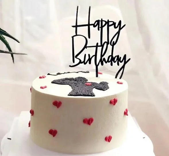 تغريسة ميلاد مكتوب عليها Happy Birthday فوق كيكة بيضاء