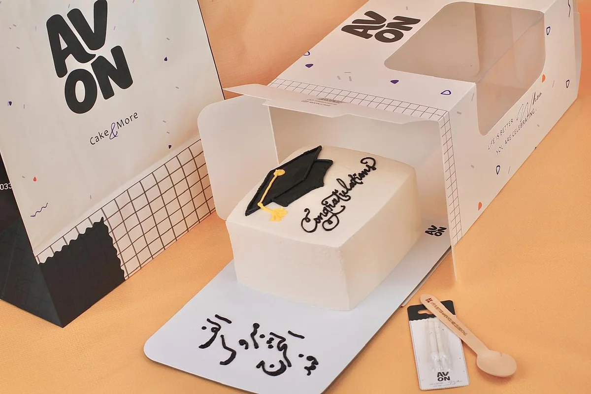 Rectangular graduation cake with a black cap and a message on the board