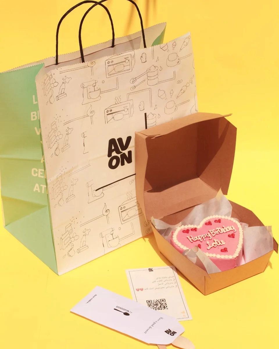 Pink 4-inch heart cake with Happy Birthday piped on top in a burger box